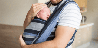 October 5 – 10: International Babywearing Week A man holding a baby in a baby carrier.