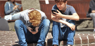 Why I Finally Caved and Let My Son Play Pokémon Go Two boys on their phone.