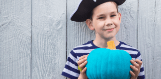 The Teal Pumpkin Project: Making Halloween Memorable for All Kids A boy holding a teal pumpkin.