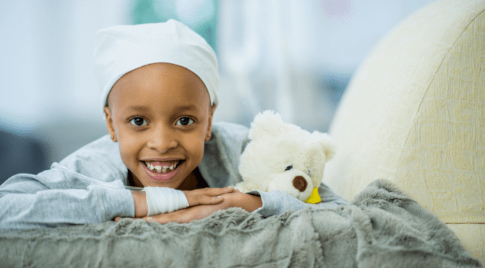 A child with cancer laying on a bed.