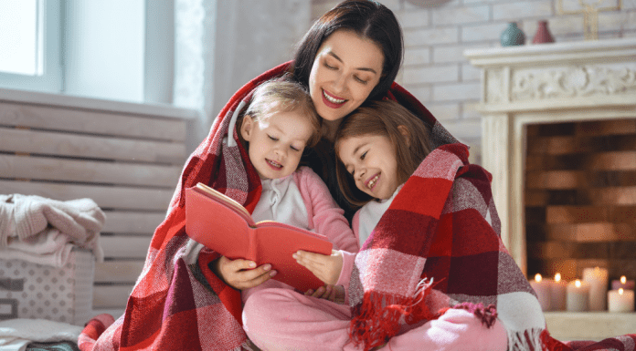 A mother reading a book to her daughters.