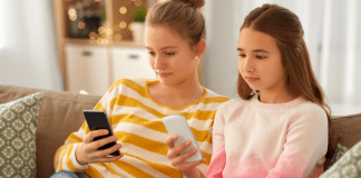 Two tweens n their cell phones.