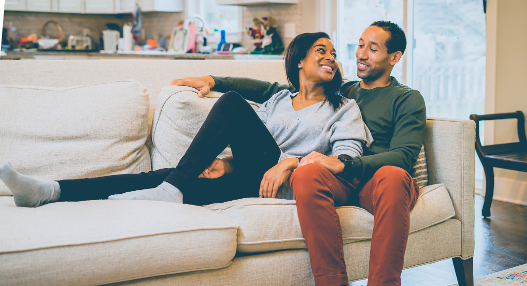 A couple cuddling on the couch.