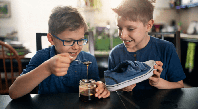 Kids putting honey into a shoe for an April Fools' trick.