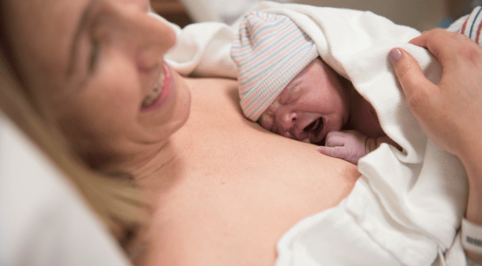 A woman holding a newborn on her chest after birth.