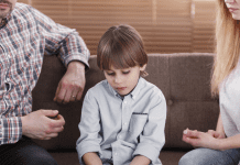 Divorce: How I Deal With Tough Questions From the Kids Sad child sitting in between his parents.
