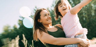 Coping with Negative Emotions as a Special Needs Parent A mom holding a special needs child.