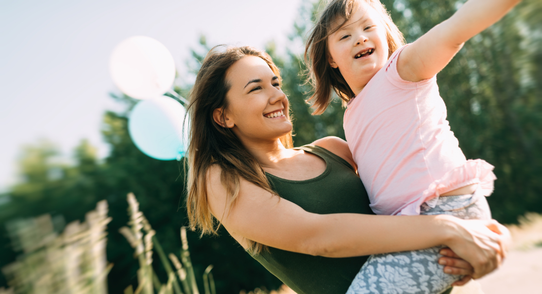 A mom holding a special needs child.