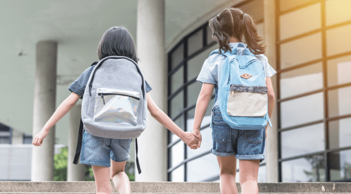 Two girls holding hands going back to school.