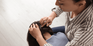 A mother checking her daughter for lice.