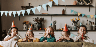Whatever Happened to the Basement Party? Kids standing behind a couch with party hats and blowers.