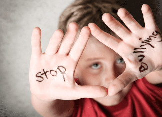 A kid holding up he hands with the words "stop byllying."