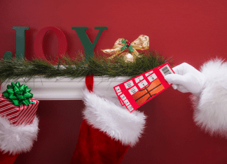 Santa putting basketball tickets into a stocking.