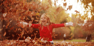 A Mom’s Guide to Westchester County :: November 2017 A girl playing in a pile of leaves.