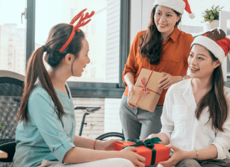 Women exchanging holiday gifts.