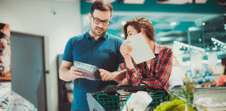 Be a Thrifty Food Shopper A couple using a list while grocery shopping.