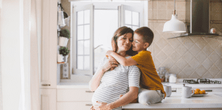 10 Praise-Worthy Ways to Spoil a Second-Time Mom A boy hugging his pregnant mom.