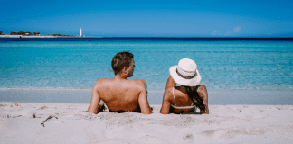 Apres – Babymoon A couple relaxing on a beach on vacation.