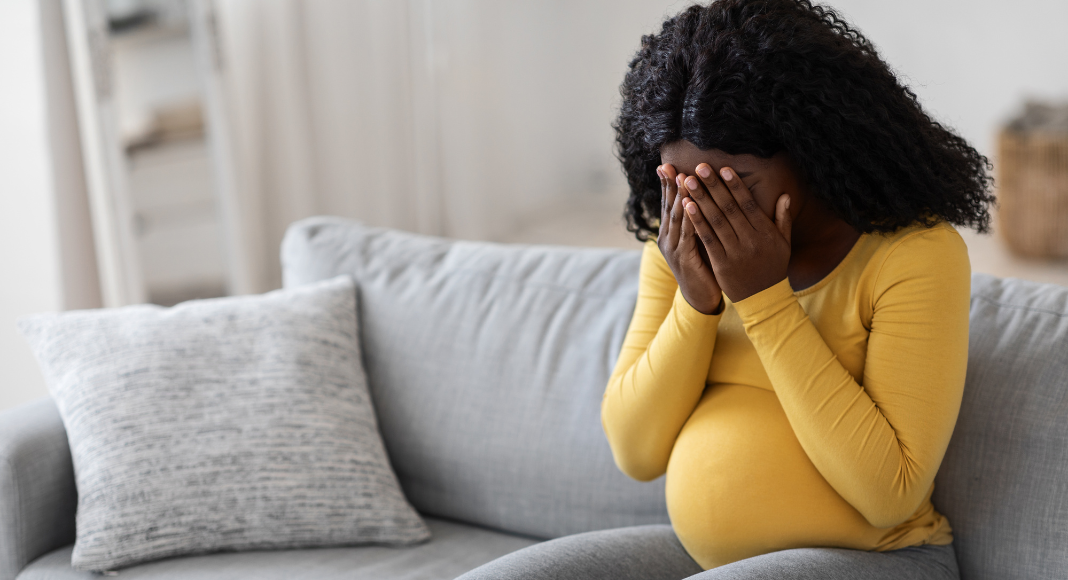 A pregnant woman crying.