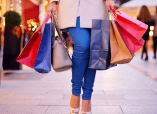 A woman walking holding shopping bags.