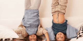 Two kids standing on their heads.