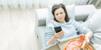 Socially Toxic: Steps to Detox and Be Social A woman on her phone eating a box of pizza.