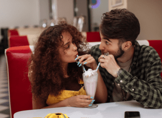 A couple sharing a milkshake on a date.