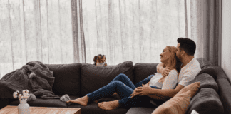 A couple cuddling on the couch.