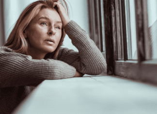 A woman upset looking out the window.