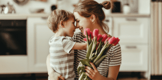 Mother’s Day Traditions A boy hugging his mom and giving her flowers on Mother's Day.