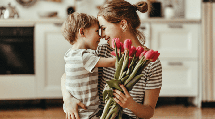Mother’s Day Traditions A boy hugging his mom and giving her flowers on Mother's Day.