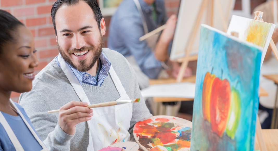 A couple during a painting class for a couples date night.