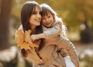 A mom holding her daughter on her back.