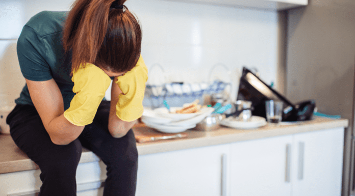 A woman sitting on a messy counter.