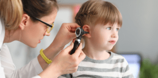 A doctor looking in a girl's ear.