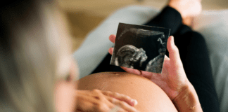 A Mom’s Guide to Pregnancy in Westchester County A pregnant woman looking at her sonogram.
