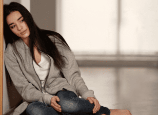 How a Carnival Helped Me Fight Grief A sad woman leaning against a wall.