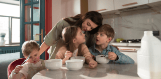 A mom with her children eating cereal.