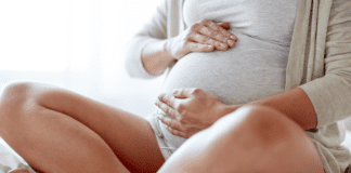 A pregnant woman holding her belly.