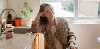 A woman sitting in her kitchen.