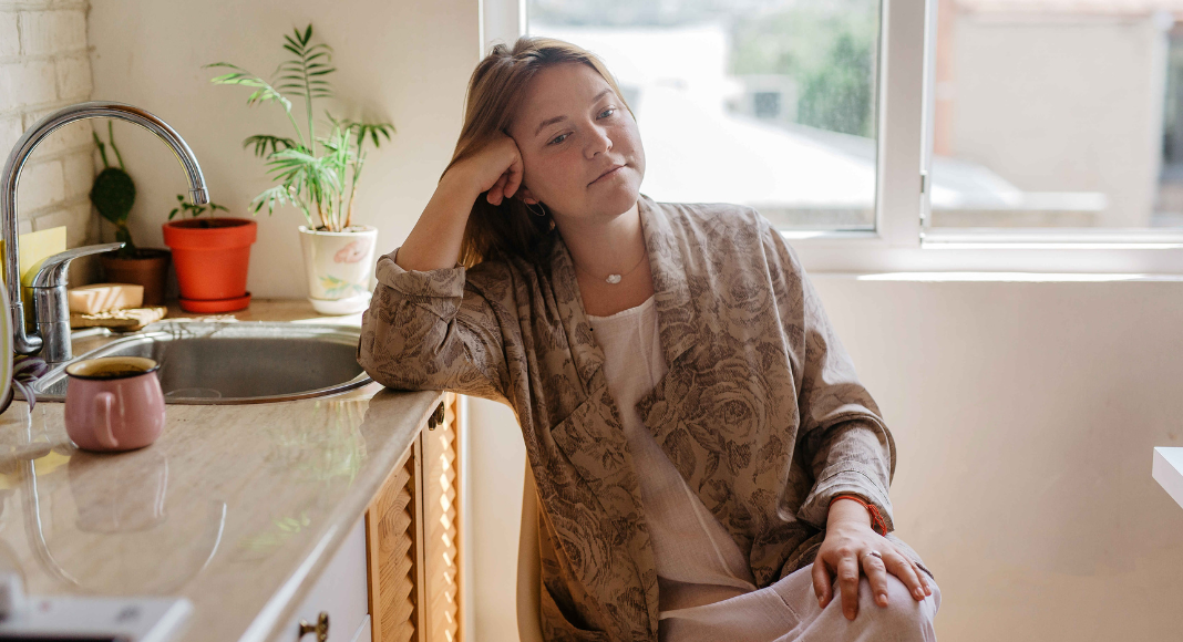 A woman sitting in her kitchen. 