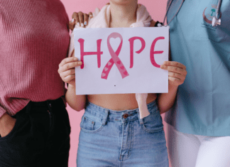 Holding a sign of hope for breast cancer awareness.