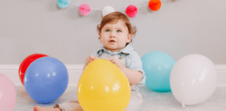 Oh-Two-dles! Themed Birthday Party A toddler boy holding balloons.