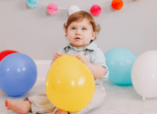 Oh-Two-dles! Themed Birthday Party A toddler boy holding balloons.