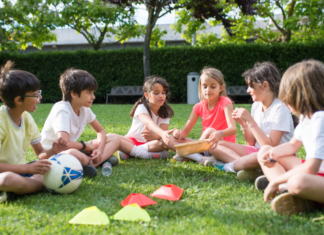 Knowing When to Say “When” With Kid Activities Kids sitting in a circle outside with a soccer ball.