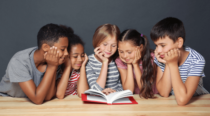 Diverse children reading a book together.