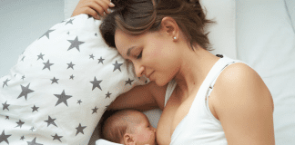 A woman laying down while breastfeeding a baby.
