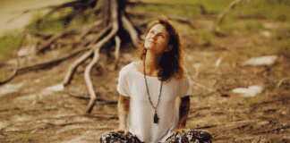 A woman sitting next to roots.