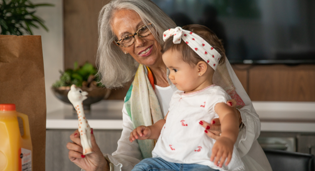A grandmother holding her toddler granddaughter. 