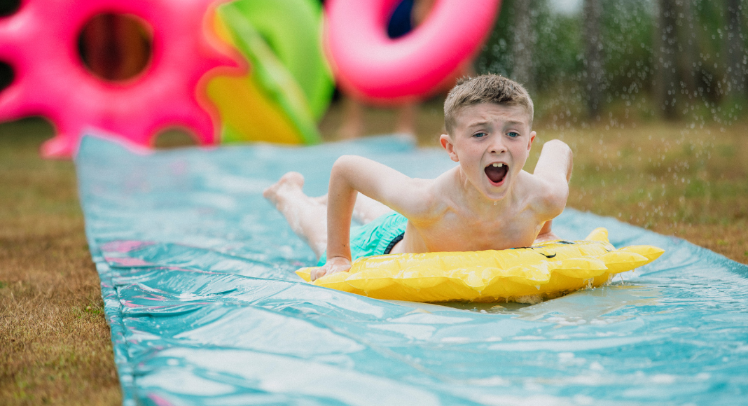 A boy on a slip and slide.